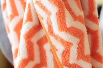 The texture of the orange and white towel has a folded zig zag motif