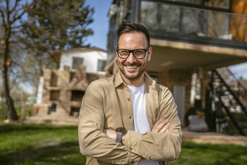 One adult man stand outdoor in front of his house happy confident