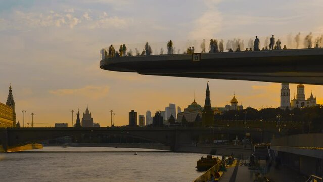 Time lapse, Soaring bridge with people above Moscow river in the park, view at Kremlin, Russia
