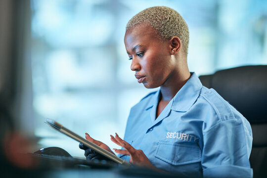 Security, working and black woman with tablet at a desk for communication, cctv app or building monitor. Digital, reading and an African safety officer typing on technology for a surveillance system - Powered by Adobe