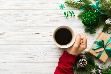 Woman holding cup of coffee. Woman hands holding a mug with hot coffee. Winter and Christmas time...