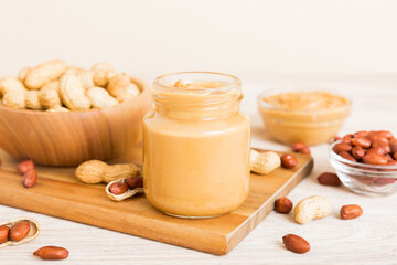 Bowl of peanut butter and peanuts on table background. top view with copy space. Creamy peanut pasta in small bowl