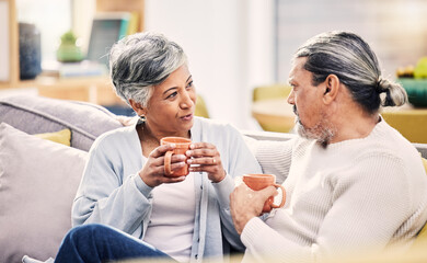 Coffee, conversation and senior couple on a sofa for bond, discussion or sharing gossip in their home. Love, tea and old people relax on couch for break, speaking or did you know drama in living room