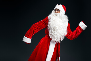 Scared emotional Santa Claus running  fast isolated on black background 