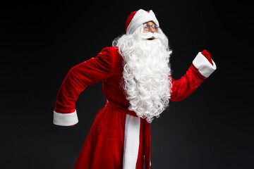 Emotional Santa Claus running, hurry up isolated on black  background. Holidays, advertisement concept
