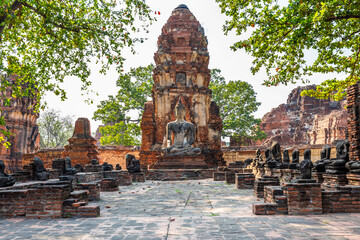 The large ancient Buddha statue in Wat Mahathat at Ayutthaya Historical Park is a popular tourist attraction. - obrazy, fototapety, plakaty