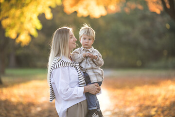 Mothers day, love family.  Family on autumn walk in nature outdoors. Mother and child with hugging tenderness