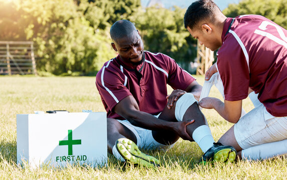 First aid, sport and black man with medic after an accident, knee pain and rugby injury. Healthcare, help and African athlete crying after a hurt muscle in sports with a doctor for medical attention