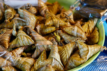 The triangular sticky rice wrapped with palm leaf or ketupat steamed