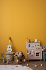 Minimalist composition of kids room interior with yellow wall, children kitchen, guitar, stylish...