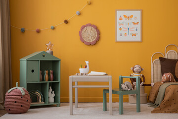 Creative composition of warm kids room interior with mock up poster frame, yellow sideboard, bed,...