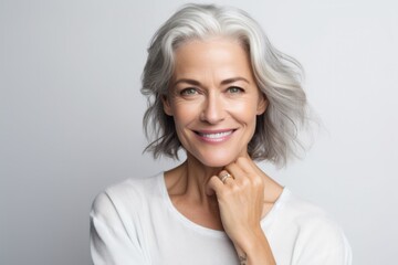 Portrait of a happy mature woman looking at camera over white background - obrazy, fototapety, plakaty
