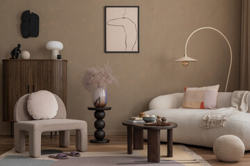 Warm and cozy composition of living room interior with mock up poster frame, boucle sofa, gray armchair, wooden sideboard, vase with dried flowers and personal accessories. Home decor. Template.