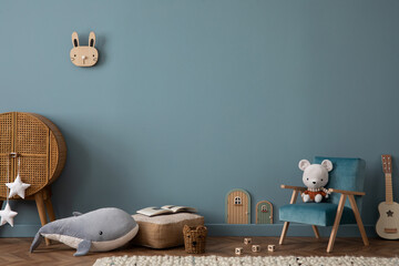 Warm and cozy living room interior with blue wall, rattan sideboard, stylish armchair, plush whale,...