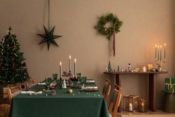 Aesthetic composition of warm dining room interior with table, green tablecloth, christmas tree,...