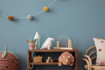 Interior design of warm kids room interior with wooden sideboard, plush toys, pillow, pink basket,...