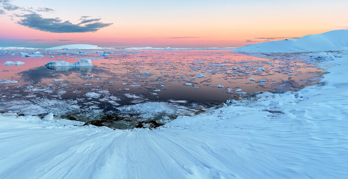 The Midnight sun over the icebergs in the Weddell Sea from the Antarctic Peninsula in Antarctica. 