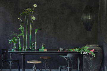 Raw composition of japandi dining room interior with black table, glass vase with green flowers,...