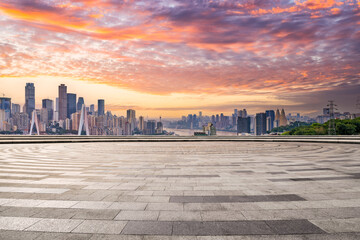 Square floor and city buildings skyline in Chongqing at sunset