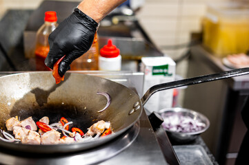 Professional chef cooking chicken curry food in wok pan on kitchen