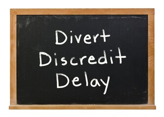 Obraz premium Divert discredit Delay written with white chalk on a black chalkboard isolated on white
