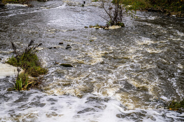 Nature, waterfall rapids. Fast current, splashes, water boils. Foam.