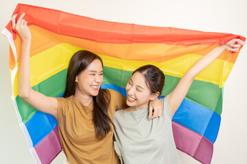 LGBT group. Good looking lesbian couples smile brightly cover rainbow flags. Asian young couple hugging each other happily, lover in love, bisexualities, homosexuality, liberty, expression, happy life