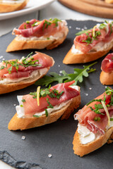 Deliziosi crostini con prosciutto crudo e crema di formaggio, antipasto italiano, cibo europeo 