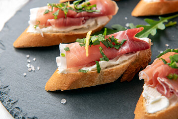 Deliziosi crostini con prosciutto crudo e crema di formaggio, antipasto italiano, cibo europeo 