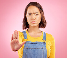 Woman, hand and stop in studio portrait with angry face, rejection or bad review by pink...