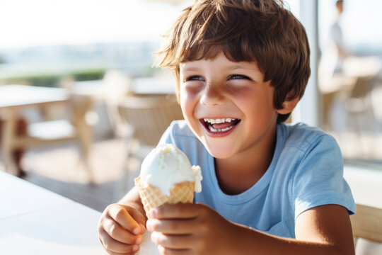 Happy child, boy eats with a smile in a cafe. Funny kid eating ice cream at the table.