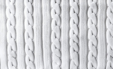 Seamless texture of white knitted fabric with pigtails. Knitted background