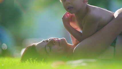 Loving Son Embraces Mother Amidst Summer Grass. Affectionate child expressing love with a hug in...