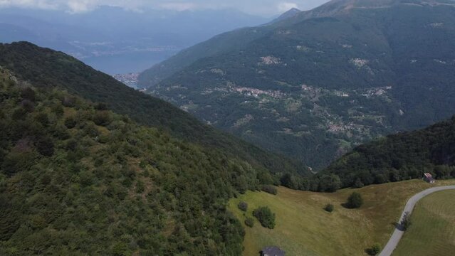 Drone footage over the green mountains surrounding Lake Como in Northern Italy's Lombardy region