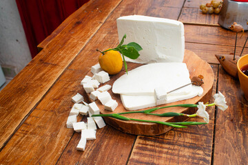 Toma superior de un queso blanco mexicano fresco en una tabla de madera en cubos y rebanadas ideal...