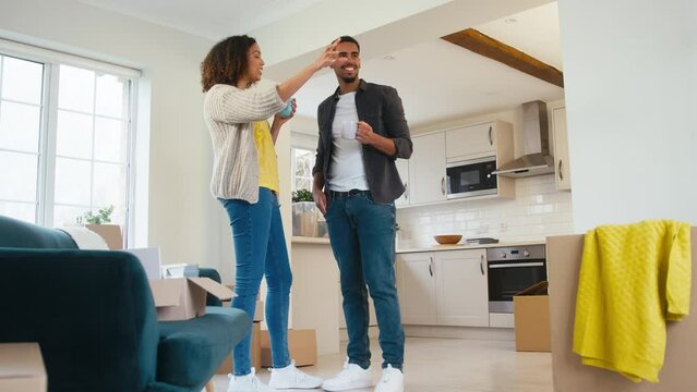 Low angle shot of couple taking coffee break from unpacking boxes in new home on moving day - shot in slow motion