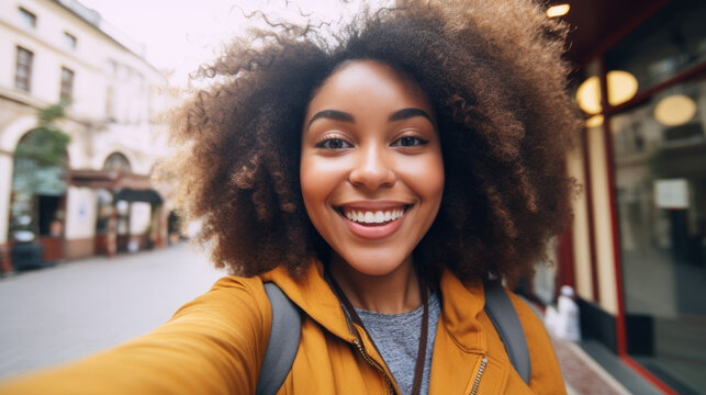 Selfie portrait of laughing black woman outside with curly hair closeup