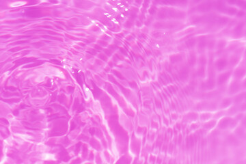 Purple water bubbles with ripples on the surface. Transparent pink colored clear calm water surface texture with splashes and bubbles. Water waves with shining pattern texture background.