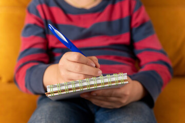 boy concentrating on drawing in his notebook in a moment of creative inspiration