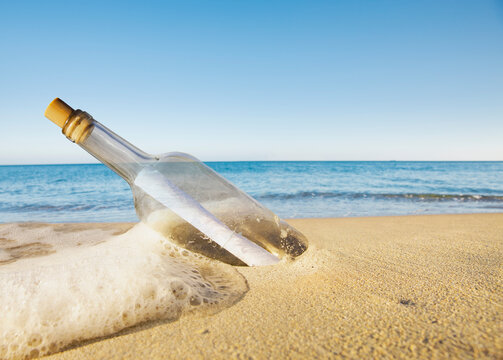 Flaschenpost in einer Flasche am Strnd in einer Welle angespült