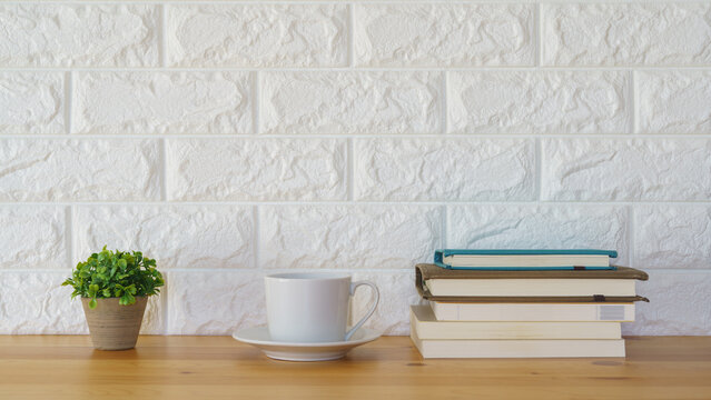 コーヒーと山積みの本・白いレンガの壁
