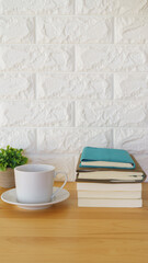 コーヒーと山積みの本・白いレンガの壁