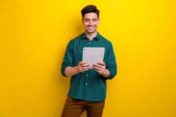 Photo of cheerful nice man hand hold apple ipad gadget writing reading news social media isolated...