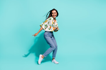 Fototapeta na wymiar Full size photo of cheerful woman dressed flower print blouse look at discount empty space dancing isolated on turquoise color background