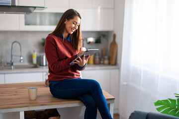 Young woman freelancer working from home on digital tablet pc.