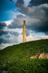 Brick making chimney behind the grass field