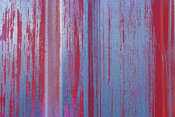 metal texture from a gray iron wall in spots of red paint