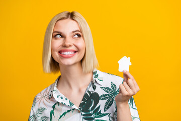 Photo portrait of attractive young woman look empty space house dressed stylish leaves print clothes isolated on yellow color background