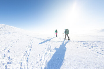Fototapeta na wymiar two tourists in winter mountains on snowshoes