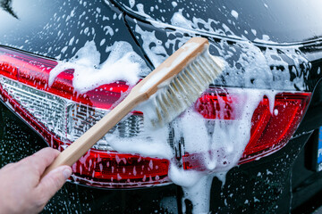 Outdoor car cleaning with a natural wood brush
